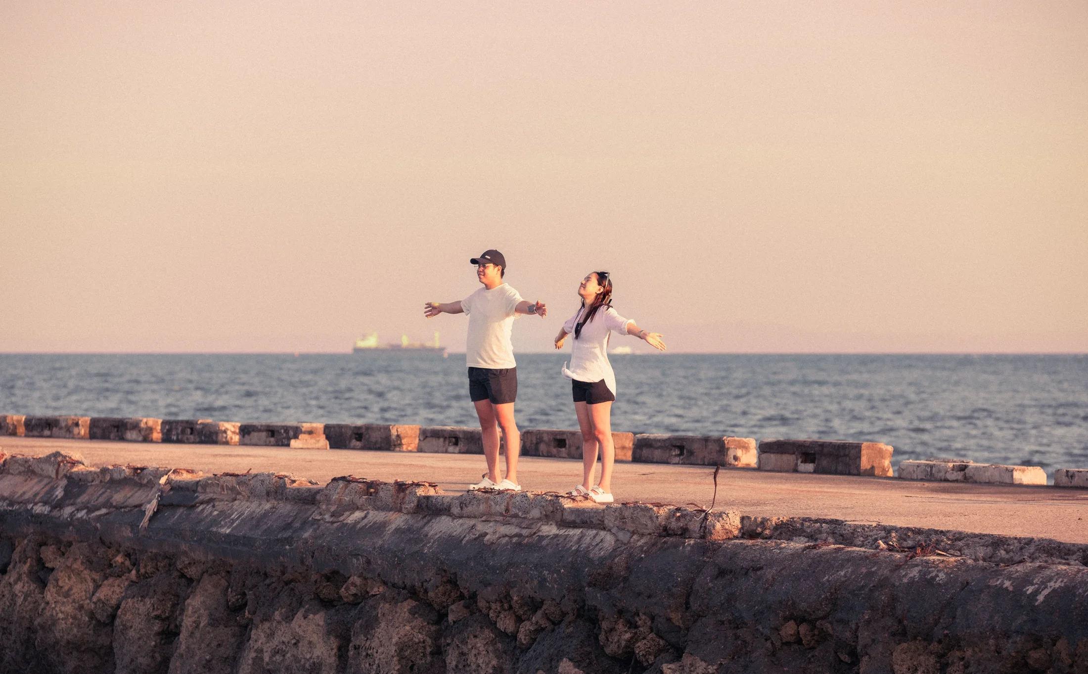 Wide shot of a couple at the harbor during a cinematic prenup session